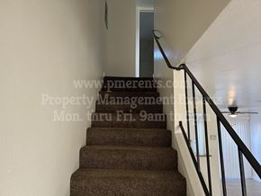 Stockton apartment for rent - A staircase with a carpeted runner and a metal railing.