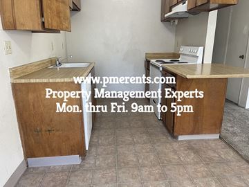 Modesto apartment for rent - A kitchen with a website address for property management experts displayed on the counter.