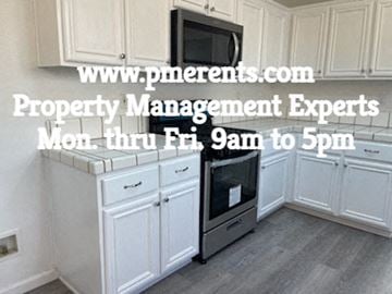 Stockton apartment for rent - A kitchen with a microwave on top of the fridge and a website address displayed.