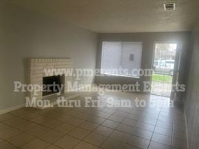 Stockton triplex for rent - an empty living room with a fireplace and a window