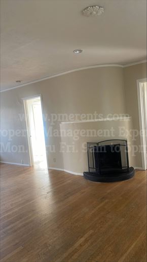 Stockton triplex for rent - A living room with a fireplace and wooden floors.