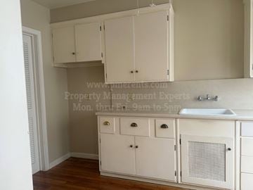 Stockton triplex for rent - A kitchen with white cabinets and a sink.