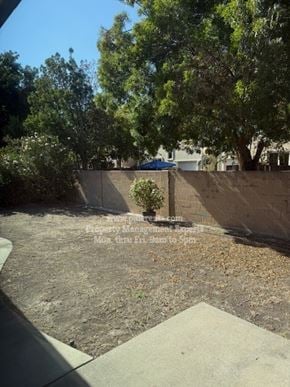 Stockton apartment for rent - A backyard with a concrete patio and a wall.