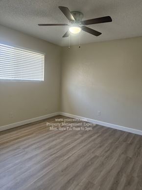 Stockton triplex for rent - A room with a ceiling fan and a window with blinds.