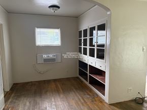 Stockton triplex for rent - A room with a window and a cabinet with drawers.