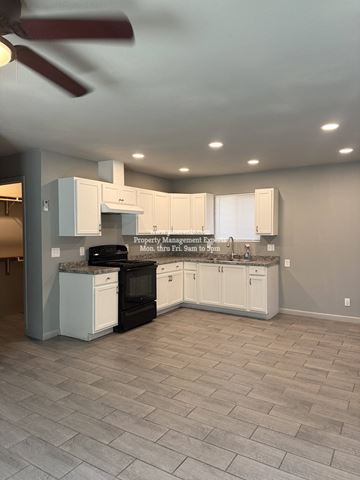 Stockton apartment for rent - A kitchen with white cabinets and a black stove top oven.