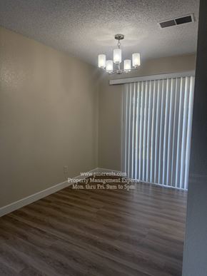 Stockton triplex for rent - A room with a chandelier and a sign that says "www.p-parents.com Property Management Experts Mon. thru Fri. 9am to 5pm".
