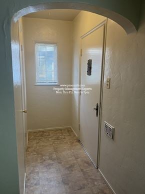 Stockton triplex for rent - A hallway with a door on the right and a window on the left.
