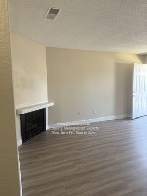 Stockton triplex for rent - A room with a fireplace and a door on the right side.