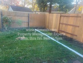 Stockton apartment for rent - a garden hose spraying water on the grass in front of a fence