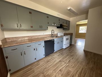 Stockton apartment for rent - A kitchen with white cabinets and a wooden floor.