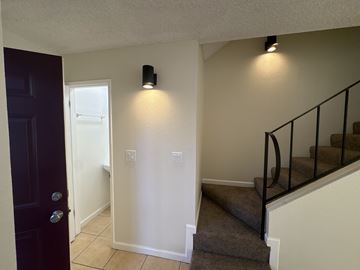 Stockton apartment for rent - A hallway with a staircase and a black door.