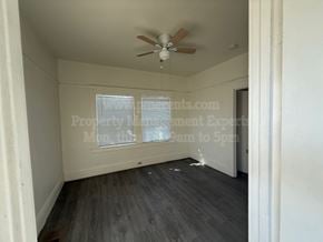 Stockton apartment for rent - A room with a ceiling fan and wooden flooring.
