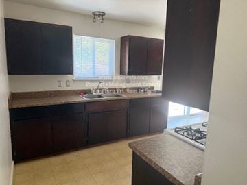 Stockton apartment for rent - A kitchen with dark brown cabinets and a countertop.