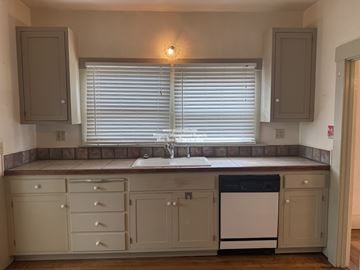 Stockton apartment for rent - A kitchen with a dishwasher and a window with blinds.