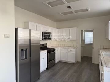 Stockton apartment for rent - A kitchen with a refrigerator, oven, and microwave.