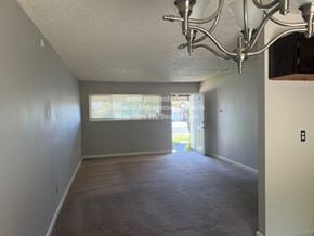 Stockton apartment for rent - A room with a carpeted floor and a chandelier hanging from the ceiling.