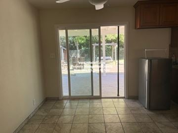 Stockton apartment for rent - A kitchen with a refrigerator and a sliding glass door leading to a backyard.