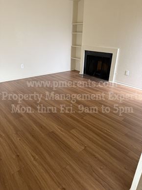 Stockton triplex for rent - a living room with wood flooring and a fireplace