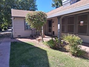Stockton apartment for rent - A white house with a brown roof and a tree in front of it.