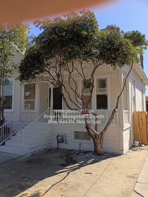 Stockton apartment for rent - A tree in front of a white house.