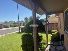 Stockton apartment for rent - A view from a house looking out to a street with cars and other houses.