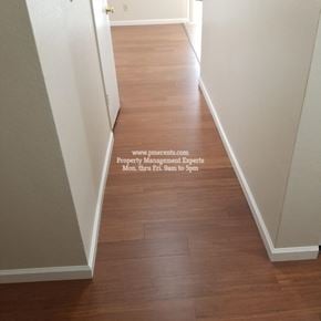 Modesto condo for rent - A hallway with wood flooring and white walls.