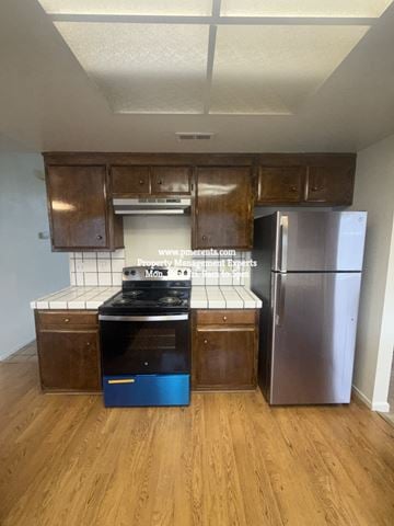 Stockton apartment for rent - A kitchen with wooden cabinets and a stainless steel refrigerator.