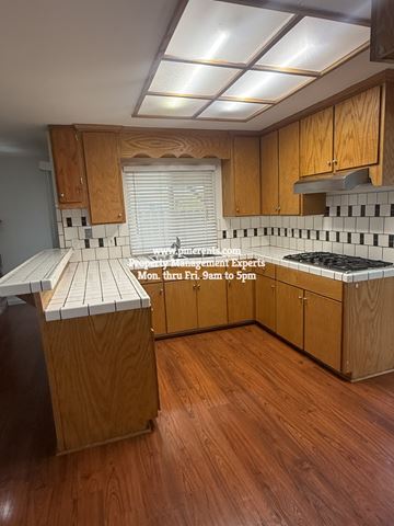 Stockton apartment for rent - A kitchen with wooden cabinets and a white countertop.