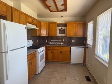 Stockton apartment for rent - A kitchen with wooden cabinets and a white refrigerator.