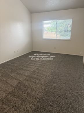 Stockton apartment for rent - A room with a carpeted floor and a window with blinds.