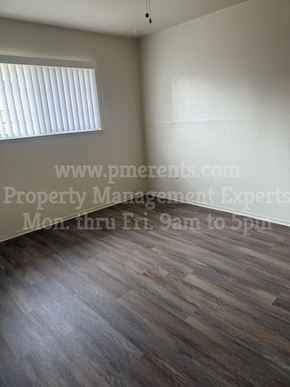 Stockton triplex for rent - an empty room with wooden floors and a window