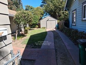 Stockton apartment for rent - A residential area with a walkway and a sign for a property management company.