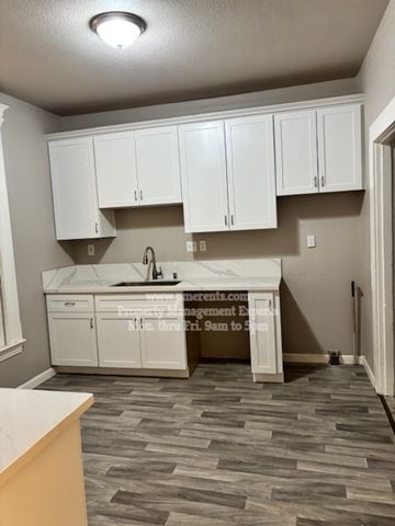 Stockton apartment for rent - A kitchen with white cabinets and a marble countertop.