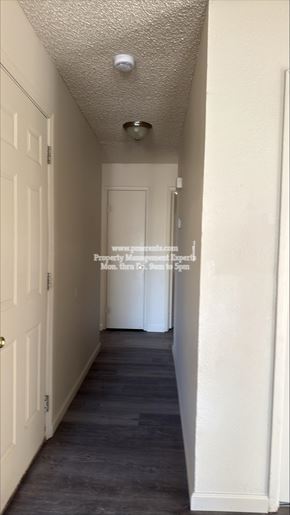 Modesto apartment for rent - A long, narrow hallway with white doors and a light on the ceiling.