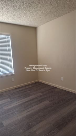 Modesto apartment for rent - A room with wooden flooring and a window with blinds.