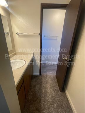 Stockton triplex for rent - A bathroom with a sink, mirror, and towel rack.