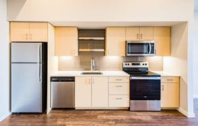 Vancouver apartment for rent - a kitchen with stainless steel appliances and white cabinets