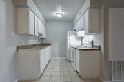 Pleasanton apartment for rent - an empty kitchen with white cabinets and a white refrigerator at Eagle View Apartments, Texas