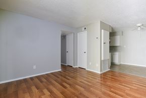 Pleasanton apartment for rent - an empty living room with wood flooring and white walls at Eagle View Apartments, Pleasanton, Texas