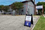 San Antonio apartment for rent - a sign in front of a building advertising car rentals at The Crossings at Montrose Apartments, San Antonio