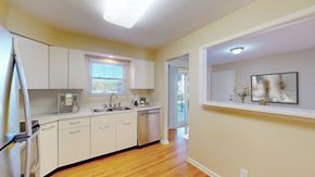 Overland Park apartment for rent - A kitchen with white cabinets and a wooden floor.