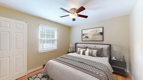 Overland Park apartment for rent - A bedroom with a bed, nightstand, and a ceiling fan.