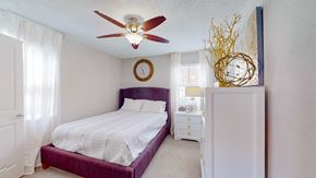 Kansas City apartment for rent - A bedroom with a purple bed and a white dresser.