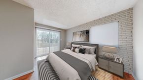 Kansas City apartment for rent - A bedroom with a large bed and a nightstand.