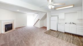 Belton townhouse for rent - an empty living room with a fireplace and a kitchen