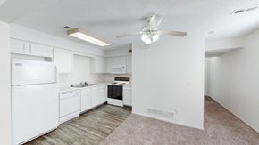 Belton townhouse for rent - an empty kitchen with white cabinets and a ceiling fan