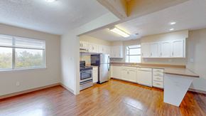 Kansas City apartment for rent - an empty kitchen with white cabinets and a wood floor
