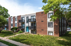 Kansas City apartment for rent - A row of red brick apartment buildings with green trees in front.