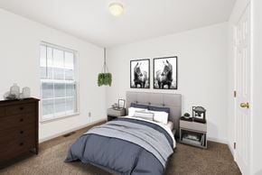 Gardner apartment for rent - A bedroom with a bed, nightstand, and two framed pictures on the wall.